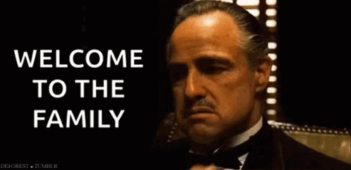 Vito Corleone from "The Godfather" gestures with his hands, captioned "Welcome to the Family"